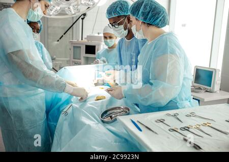 les médecins se sont mis en uniforme sur la plaie une crème antibiotique, recouverte d'une éponge de gaze pendant la chirurgie Banque D'Images