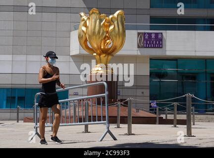 (200729) -- HONG KONG, le 29 juillet 2020 (Xinhua) -- UN citoyen qui se présente sur la place Bauhinia dorée de Hong Kong, dans le sud de la Chine, le 29 juillet 2020. Le Centre pour la protection de la santé (CHP) de Hong Kong a signalé mercredi 118 autres cas confirmés de COVID-19, ce qui porte le nombre total de cas de COVID-19 à Hong Kong au-dessus de 3,000. Ce fut le huitième jour de droit où les cas supplémentaires quotidiens à Hong Kong ont dépassé les 100. (Xinhua/Lui Siu Wai) Banque D'Images