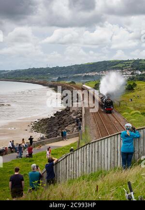 Llanelli, pays de Galles. 29 juillet 2020. Les gens regardent le moteur à vapeur Britannia 70000 se rendre le long de la magnifique ligne côtière rurale de Llanelli, tandis que la locomotive traverse le sud du pays de Galles. Depuis son retrait du service en 1966, les moteurs ont été préservés et sont maintenant la propriété de la Locomotive Royal Scot et de General Trust et transportent des passagers sur des circuits de lignes principales à travers le Royaume-Uni crédit : Robert Melen/Alay Live News Banque D'Images