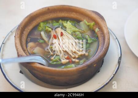 Garniture de bak kut Teh ou Hokkiens avec champignon à aiguille doré Ou Enokitake en pot de faïence dans un bouillon populairement servi dans Malaisie, Singapour Banque D'Images