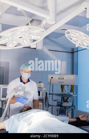 Insufflateur caucasien mâle utilisant un appareil pour fournir un composant gazeux pendant la narcose par inhalation. Banque D'Images