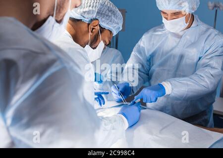 Équipe de professionnels divers surgeons performing chirurgie sur un patient à l'hôpital salle d'opération. Banque D'Images