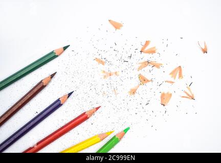 Quelques copeaux de crayon et six crayons de couleur différente sur un fond en papier Banque D'Images