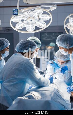 Équipe de professionnels divers surgeons performing chirurgie sur un patient à l'hôpital salle d'opération. Banque D'Images