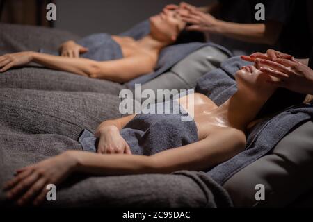 les femmes bénéficient d'un massage du visage. soins de la peau et du corps au spa. deux femmes caucasiennes reçoivent un massage au salon de beauté Banque D'Images