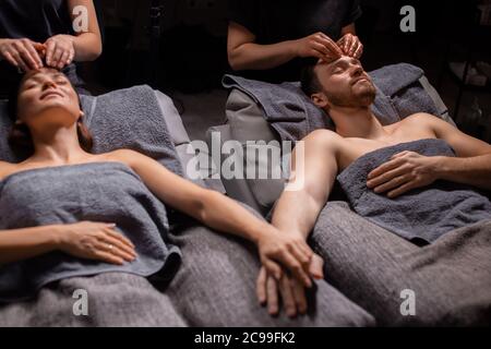 charmant couple marié profitez d'un massage de la tête dans un salon de bien-être moderne. concept de soins de beauté, mode de vie sain, concept de peau lisse Banque D'Images