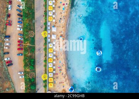 Vue aérienne de la plage de sable avec parasols, mer bleue en été Banque D'Images