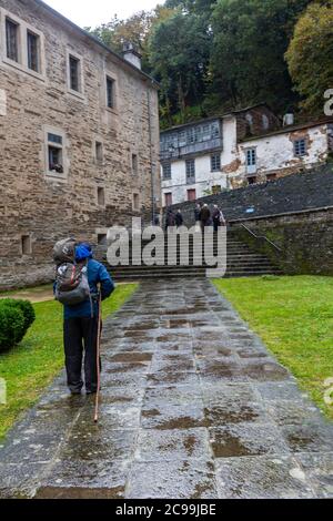 Pèlerin quittant le monastère de San Xulián de Samos, Samos, Galice, Espagne Banque D'Images