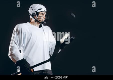 Le seul but pour a été inscrit par le joueur de hockey sur glace professionnel en uniforme blanc et une coiffure qui tient un bâton de hockey et le jetant dans l'Ia rondelle Banque D'Images