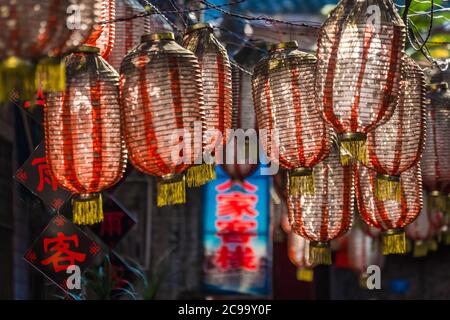 Feng Huang, Chine - août 2019 : variété de lanternes chinoises colorées accrochées à des bâtiments dans une ruelle étroite de la vieille ville Banque D'Images