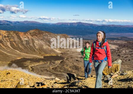 Randonnée pédestre personnes randonneurs trekking sur les montagnes en altitude trek. Couple de touristes qui piétinent en Nouvelle-Zélande lors de la randonnée sur la piste de Tongariro Alpine Banque D'Images