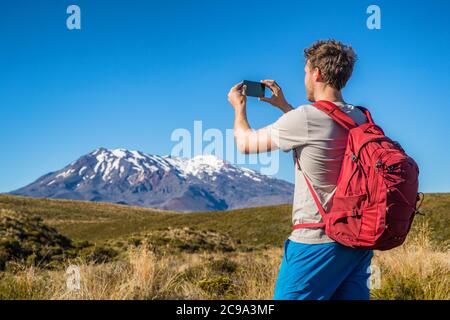 Randonneur touristique prenant des photos avec le téléphone des montagnes en Nouvelle-Zélande lors de la randonnée sur la piste de traversée de Tongariro Alpine en Nouvelle-Zélande, Nouvelle-Zélande. Déplacement Banque D'Images