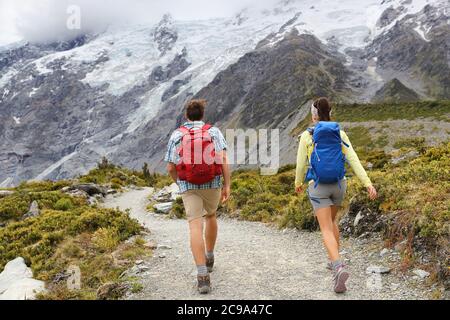 New Zealand Travel Tramping randonneurs marchant sur le sentier de Hooker Valley Track en Nouvelle-Zélande Aoraki/Mt Cook. Couple de touristes randonnée dans les montagnes sur Banque D'Images