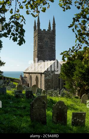 L'église paroissiale de Saint-Morwenna et Saint-Jean-Baptiste, Morwenstow, Cornouailles, Royaume-Uni, avec de vieux pierres tombales empilées dans le cimetière. Banque D'Images