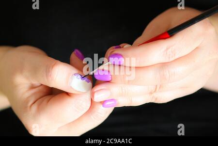 Femme se faisant manucure elle-même à la maison peinture des ongles avec aquarelle, vu seulement les mains Banque D'Images