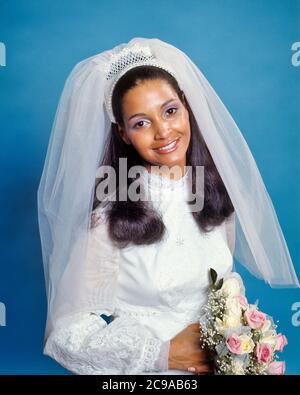 ANNÉES 1970 SOURIRE JEUNE FEMME AFRO-AMÉRICAINE MARIÉE TENANT UN BOUQUET PORTANT UNE ROBE DE MARIAGE COURT NET VOILE REGARDANT LA CAMÉRA - KB8747 HAR001 HARS ÉVÉNEMENT SAINTETÉ COPIE DEMI-LONGUEUR FEMMES MARIAGE PERSONNES VOILE CÉRÉMONIE MARIÉE CONTACT ŒIL RÊVES BONHEUR GAI ÉPOUSES COUTUMES AFRO-AMÉRICAINES TRADITION AFRO-AMÉRICAINE OCCASION NOIR ETHNICITÉ SOURIRES JEUNE ADULTE JOYEUSE HAR001 AFRO-AMÉRICAINS À L'ANCIENNE Banque D'Images