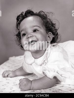 PORTRAIT DES ANNÉES 1960 SOURIANT BÉBÉ AFRO-AMÉRICAIN ALLONGÉ SUR LE VENTRE ÉLEVÉ SUR SES COUDES VÊTU D'UNE JOLIE ROBE EN COTON BLANC - N1076 HAR001 HARS STYLE DE VIE FEMMES STUDIO SHOT SAINTETÉ VIE VIE VIE COPIE ESPACE DEMI-LONGUEUR EXPRESSIONS B&W BONHEUR ESTOMAC JOYEUX AFRO-AMÉRICAINS AFRO-AMÉRICAINS NOIR ETHNIE SUR LES COUDES SOURIANTS CROISSANCE JEUNES BÉBÉ FILLE NOIR ET BLANC HAR001 AFRO-AMÉRICAINS À L'ANCIENNE Banque D'Images