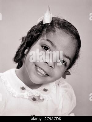 PORTRAIT DES ANNÉES 60 BRILLANT GRAND-YEUX SOURIANT AFRO-AMÉRICAIN PRÉ-ADOLESCENTE JEUNE FEMME CHEVEUX LONGS BOUCLES TÊTE INCLINÉE REGARDER L'APPAREIL PHOTO - N1715 HAR001 HARS FEMMES STUDIO PRISE DE VUE SAINTETÉ MAISON VIE COPIE ESPACE FEMMES PERSONNES INSPIRATION S'OCCUPANT ADOLESCENT JEUNE FILLE CONFIANCE B&W OEIL CONTACT RÊVES BONHEUR BIEN-ÊTRE BRILLANT TÊTE ET FORCE ÉPAULES AFRO-AMÉRICAINS COURAGE BOUCLES AFRO-AMÉRICAINES EXCITATION LEADERSHIP PUISSANT NOIR ETHNICITÉ ORIENTATION FIERTÉ OPPORTUNITÉ CONCEPTUEL ÉLÉGANT ADOLESCENT INCLINÉ GRAND ANGLE JEUNES AVANT L'ADOLESCENCE FILLE NOIR ET BLANC HAR001 OLD FASHIONED AFRO-AMÉRICAINS Banque D'Images