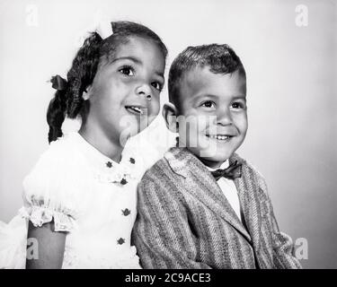 PORTRAIT DES ANNÉES 1960 GARÇON AFRO-AMÉRICAIN ET FILLE ASSIS ENSEMBLE SŒUR AÎNÉE CHUCHOTANT À FRÈRE PLUS JEUNE - N1753 HAR001 HARS FORTE JOIE VIE CÉLÉBRATION FEMMES FRÈRES STUDIO SHOT SANTÉ VIE VIE VIE COPIE ESPACE AMITIÉ DEMI-LONGUEUR SOINS HOMMES FRÈRES ET SŒURS CONFIANCE SŒURS EXPRESSIONS B&W BONHEUR BIEN-ÊTRE FORCE AFRO-AMÉRICAINS AFRO-AMÉRICAIN ET NOIR ETHNICITÉ FIERTÉ À CONNEXION DE FRÈRE ÉLÉGANT ATTACHEMENT PERSONNEL AFFECTION COOPÉRATION ÉMOTION CROISSANCE JEUNES ENSEMBLE JEUNE NOIR ET BLANC HAR001 OLD FASHIONED AFRO-AMÉRICAINS Banque D'Images