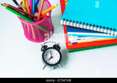 Réveil, pile de livres et crayons colorés dans la tasse. Concept rentrée, vue du dessus Banque D'Images