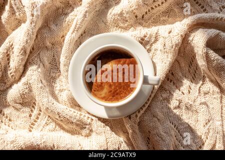 Une tasse de café ou de chocolat chaud sur une couverture tricotée confortable, vue du dessus, plat Banque D'Images