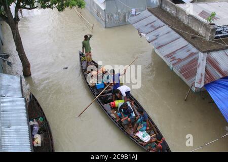 Les personnes touchées par les inondations utilisent des bateaux au lendemain à Dohar.un tiers du Bangladesh est sous l'eau après certaines des pluies les plus abondantes depuis une décennie, laissant plus de 3 millions de personnes affectées par des maisons et des routes dans des villages inondés, ont déclaré des responsables du Centre de prévision et d'alerte des inondations (FFWC). Banque D'Images