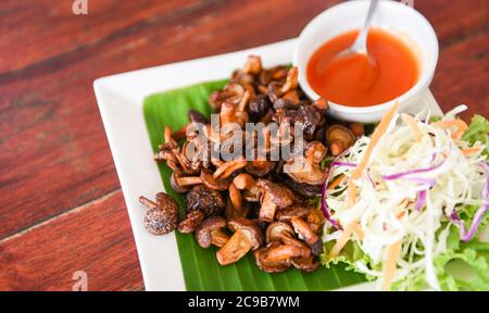 Délicieux champignons frits dans une assiette sur une table en bois, vue du dessus / champignons shiitake cuits frits avec sauce tomate et légumes Banque D'Images