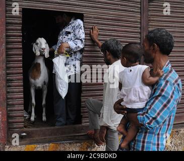 Mumbai, Inde. 29 juillet 2020. Un homme avec une chèvre à l'entrée d'un marché de bétail de fortune devant Eid al-Adha.les ventes de chèvres et de moutons ont considérablement chuté cette année en raison de la crise du coronavirus (Covid-19) ainsi que du confinement. Crédit : SOPA Images Limited/Alamy Live News Banque D'Images