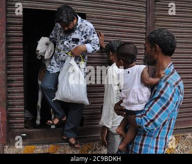 Mumbai, Inde. 29 juillet 2020. L'homme sort avec une chèvre d'un marché de bétail de fortune avant Eid al-Adha.les ventes de chèvres et de moutons ont considérablement chuté cette année en raison de la crise du coronavirus (Covid-19) ainsi que le verrouillage. Crédit : SOPA Images Limited/Alamy Live News Banque D'Images