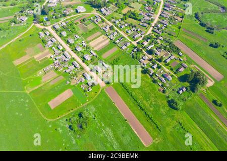 Vue aérienne depuis les hauteurs d'un village rural avec des champs de légumes Banque D'Images