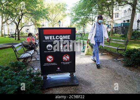 Washington, États-Unis. 29 juillet 2020. Une femme passe devant un avis de prévention de la propagation du COVID-19 à New York, aux États-Unis, le 29 juillet 2020. Crédit : Wang Ying/Xinhua/Alay Live News Banque D'Images