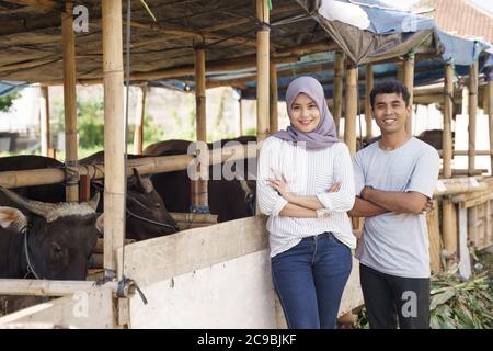 homme et femme heureux debout dans la ferme. eid adha sacrifice concept Banque D'Images