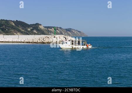 Un bateau de pêche entre dans le port de la mer Méditerranée (Pesaro, Italie, Europe) Banque D'Images