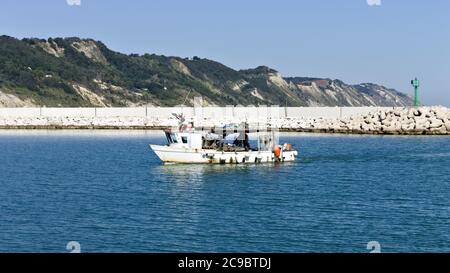 Un bateau de pêche entre dans le port de la mer Méditerranée (Pesaro, Italie, Europe) Banque D'Images