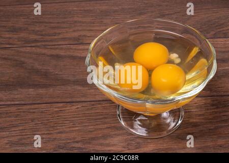 Trois œufs crus dans un bol en verre. Le contenu des œufs de poulet pour la cuisson des œufs et autres plats. Banque D'Images