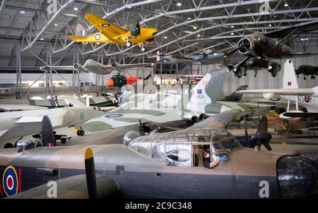 Samantha Archetti, conservateur préventif, nettoie le poste de pilotage d'un bombardier Avro Lancaster au Musée impérial de la guerre de Duxford alors que l'attraction se prépare à rouvrir au public samedi après l'assouplissement des restrictions de confinement en Angleterre. Banque D'Images