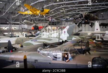 Samantha Archetti, conservateur préventif, nettoie le poste de pilotage d'un bombardier Avro Lancaster au Musée impérial de la guerre de Duxford alors que l'attraction se prépare à rouvrir au public samedi après l'assouplissement des restrictions de confinement en Angleterre. Banque D'Images