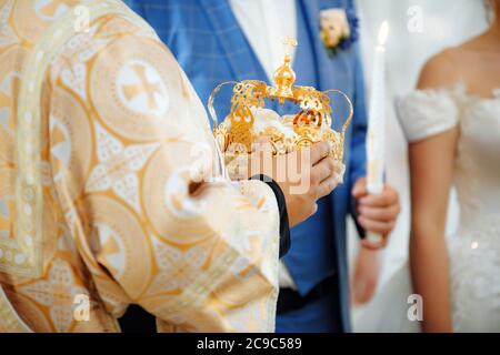 Gros plan des mains du prêtre cristian avec couronne pour le mariage Banque D'Images
