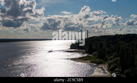 Hambourg, Allemagne. 11 juillet 2020. Les gens marchent le long de la plage d'Elbe dans des fissures tandis que le soleil se reflète sur l'eau (vue aérienne avec un drone). En arrière-plan, vous pouvez voir les tours de la centrale électrique de Wedel. Credit: Jonas Walzberg/dpa/Alay Live News Banque D'Images