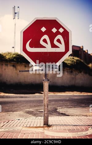 Signal de signalisation signalant un virage dangereux dans une route humide après la pluie au Maroc Banque D'Images