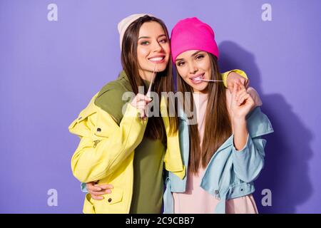 Portrait en gros plan de jolies filles gaies enjouées et enjouées pistolets à mastiquer ayant plaisir à tromper isolé sur brillant vif Banque D'Images