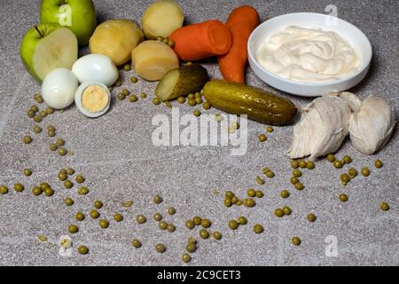 Ingrédients pour salade Olivier. Filet de poulet bouilli, pois verts, pommes de terre bouillies, carottes bouillies, cornichons marinés, mayonnaise, pommes vertes et poussins Banque D'Images