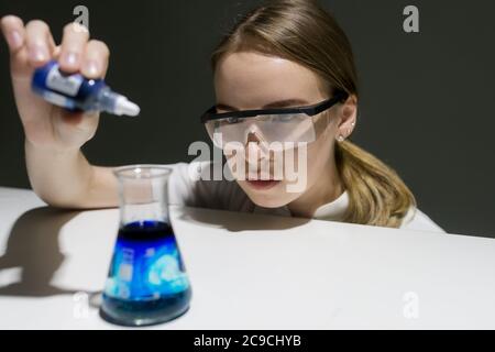 fille chimiste dans le laboratoire conduit une expérience Banque D'Images