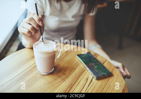 Une femme boit du lait au lait de matcha rose.ambiance de détente.Smart phone sur une table. Image floue, mise au point sélective Banque D'Images