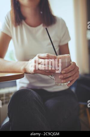 Femme boit le lait de matcha rose dans le café.ambiance de relaxation.image floue, foyer sélectif Banque D'Images