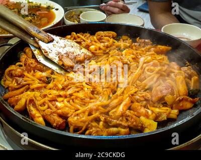 Dak-galbi, côte de poulet épicée sautée, légumes et nouilles sur le gril - Corée du Sud. La nourriture populaire coréenne parmi les touristes étrangers. Banque D'Images