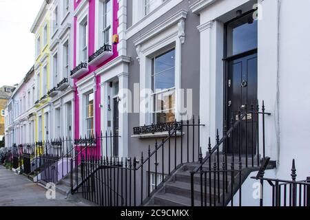 Rangée de maisons typiques colorées et d'escaliers à Notting Hill, Londres, Royaume-Uni. Façades de maisons anglaises colorées aux couleurs bleu, rose, jaune et blanc. Britannique Banque D'Images