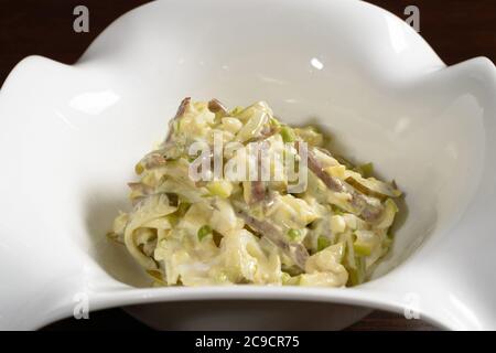 Salade servie dans le restaurant bacon avec des cornichons assaisonnés de mayonnaise, gros plan. Photos des menus du restaurant et du café Banque D'Images