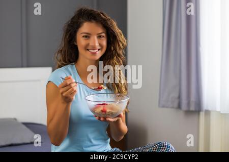 Belle femme aime manger des céréales pour le petit déjeuner. Banque D'Images