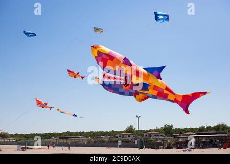 Beaucoup de grands cerfs-volants colorés survolant la plage du camping Vittoria, Rosolina Mare, Veneto, Italie. Banque D'Images